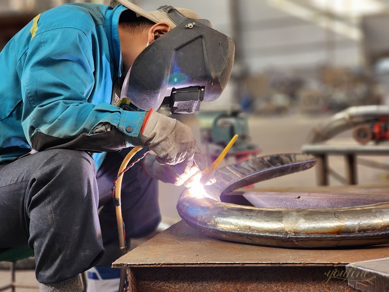 Welding the modern stainless steel abstrac sculpture